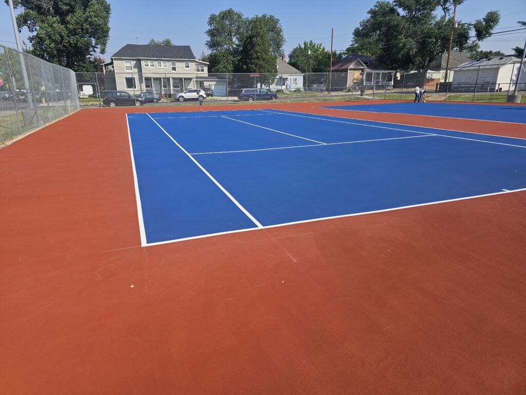 Tennis court maintenance and resurfacing completed in Pocatello, red out of bounds and tournament blue in bounds.