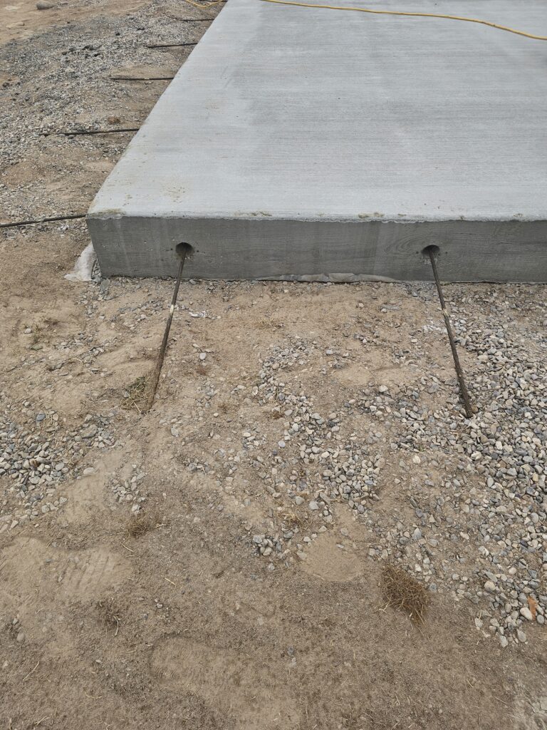 post tension cables sticking out of a concrete slab for a sports court.