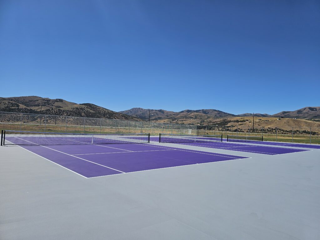 Tennis courts resurfaced in purple and gray with beautiful mountain back drop. USTA Lines also applied.